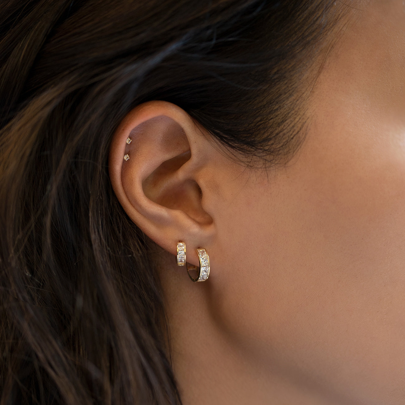 caption: Model wearing earring on first piercing